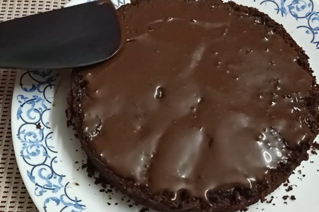 applying cocolate syrup on cake